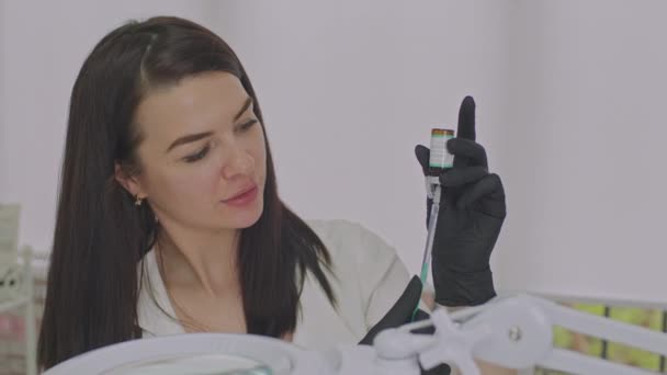 Retrato de uma médica a encher uma seringa com uma vacina. — Vídeo de Stock