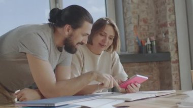 Arkadaşlar ortak bir projede birlikte çalışıyorlar, gülümsüyorlar ve gülüyorlar..