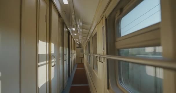 Corredor vacío de un compartimento de vagón en movimiento, con resplandor solar en el interior — Vídeos de Stock