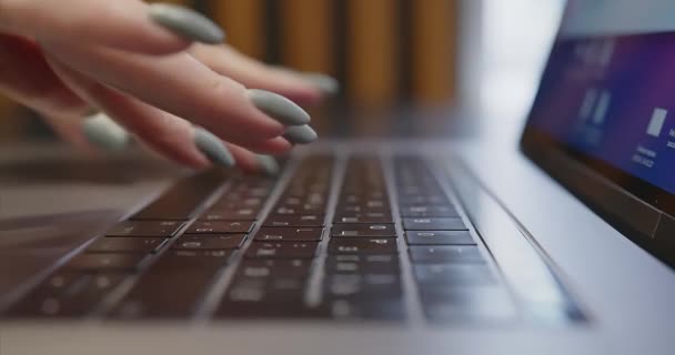 Närbild av kvinnliga fingrar med manikyr skriva text på laptop tangentbord. — Stockvideo