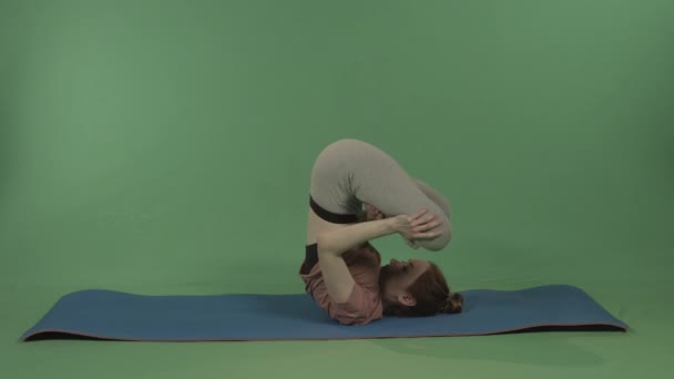 Une jeune, jolie fille fait du yoga sur un fond de chromakey vert. — Video