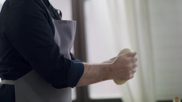 Portret van een jonge knappe chef-kok op het werk. De kok bereidt deeg. — Stockvideo