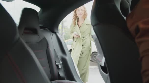 Una bella, giovane ragazza siede sul sedile posteriore di una macchina. Un giro in taxi. — Video Stock
