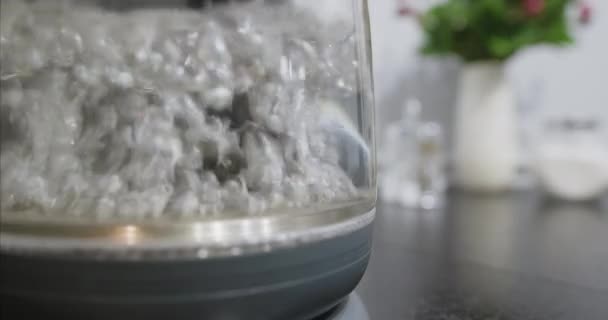 Close-up of boiling water in transparent glass container. Seething clear liquid — Stock Video