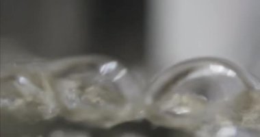 Şeffaf cam kabın içinde kaynayan suya yakın çekim. Berrak sıvı