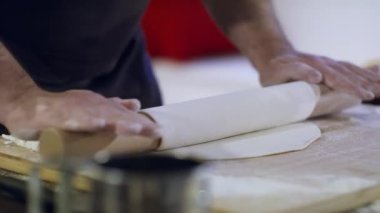 Bir aşçının ve hamurun yakın çekimi. Erişte için hamur masanda