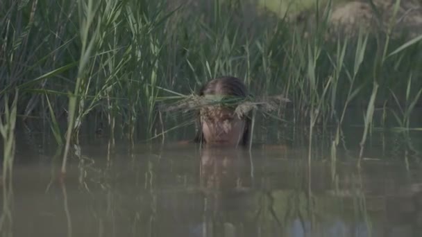 Prachtig watermeisje met een krans op haar hoofd, glimlachend komt uit het water — Stockvideo