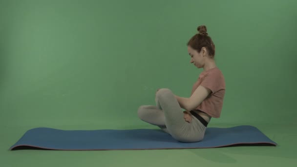 Une jeune, jolie fille fait du yoga sur un fond de chromakey vert. — Video