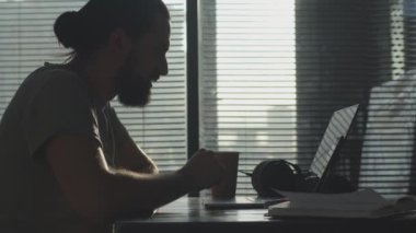 Genç bir çalışan çalışma gününden sonra ofiste oyalanıyor. Fazla mesai.