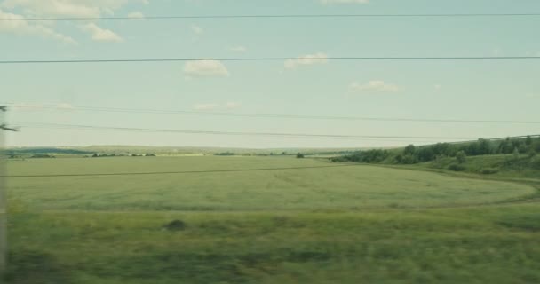 Hareket eden bir trenin penceresinden bak. Özel evleri olan kırsal alan. — Stok video