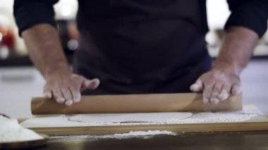 Yuvarlanan hamura merdaneyle yakın çekim.