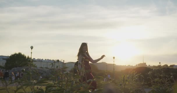 Ung vacker flicka dansar i staden mot bakgrund av solnedgången himlen. — Stockvideo