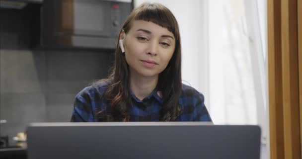 Retrato de mujer con auriculares inalámbricos, hablando en un enlace de vídeo en Internet — Vídeos de Stock