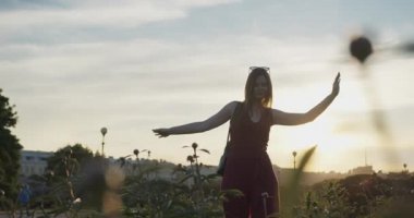 Gün batımının arka planında dans eden güzel bir kız..