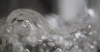 Kaynayan suyu şeffaf bir tabakta ya da bir su ısıtıcısında yakın plan çek.