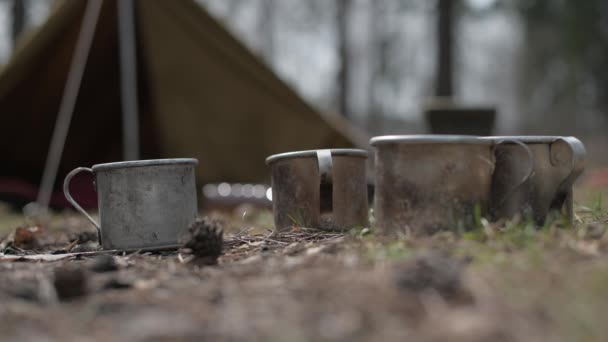 Großaufnahme von Tassen auf dem Campingplatz vor dem Hintergrund eines Zeltes. Videoclip