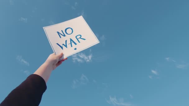 Großaufnahme eines Pappschildes mit der Aufschrift "Kein Krieg am blauen Himmel" — Stockvideo