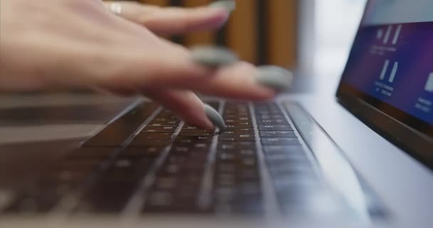 Крупним планом жіночі пальці з манікюрним набором тексту на клавіатурі ноутбука . — стокове відео