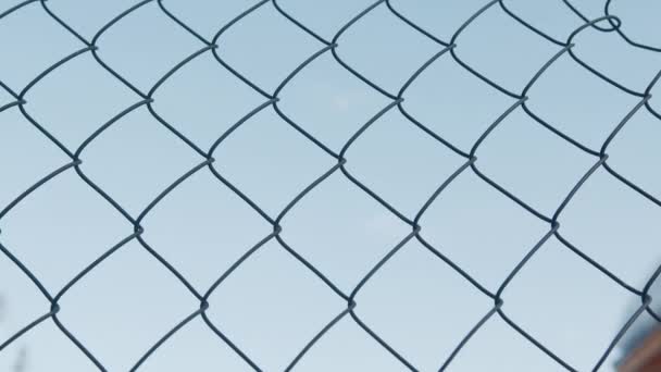Zbliżenie znak z napisem No war in the blue sky through the fence bars — Wideo stockowe