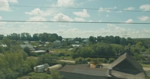 Vista desde la ventana de un tren en movimiento. Paisaje rural con casas particulares. Fotografías de stock