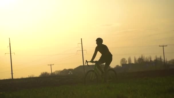 Silhuett av en cyklist på en gruscykel rider en stig i skogen — Stockvideo