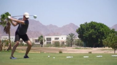 Golf Sahası. Golf sopasıyla pratik yapan bir adam. Yavaş çekim