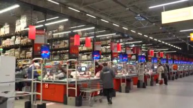 Renkli rafları ve tanınmayan müşterileri olan soyut bulanık süpermarket koridoru