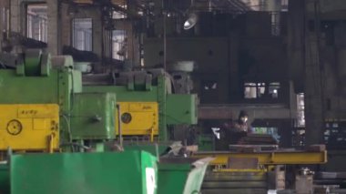 Heavy Industry Engineering Factory Interior with Industrial Worker Using Angle Grinder and Cutting a Metal Tube. Kyiv, Ukraine. 30.03.2022.