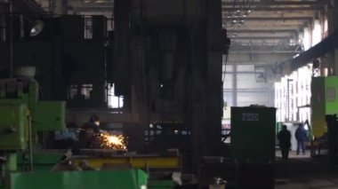 Heavy Industry Engineering Factory Interior with Industrial Worker Using Angle Grinder and Cutting a Metal Tube. Kyiv, Ukraine. 30.03.2022.
