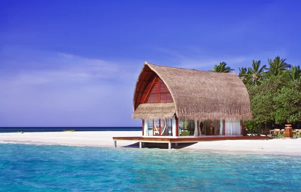 Пейзаж фото пляжного домика в Мальдивском океане с голубым небом — стоковое фото