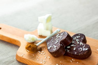 Masanın üzerinde hindistan cevizi yağı, cips ve kakaodan yapılmış el yapımı çikolatalar var. Doğru beslenmenin tarifine göre tatlı. Kilo kaybı için diyet