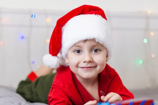 一个戴着圣诞老人帽子的可爱男孩的画像 有趣的微笑的孩子 圣诞音乐会 — 图库照片