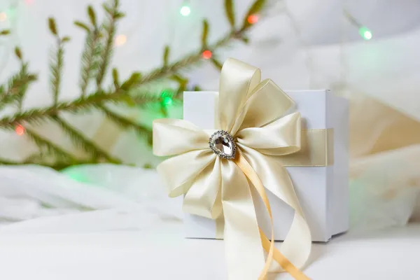 一种圣诞礼物 用漂亮的弓箭装饰在浅色的背景上 如果有枝条的话 有选择的重点 圣诞节和新年的概念 横幅的背景 — 图库照片