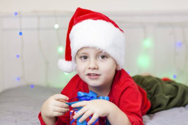 Noel Baba şapkalı şirin bir çocuğun portresi. Gülen komik çocuk. Hediyeler, oyuncaklar, neşe, kutlama. Noel konseri.