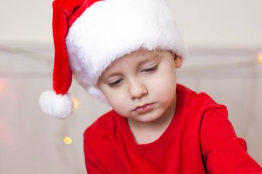 Noel Baba şapkalı şirin bir çocuğun portresi. Gülen komik çocuk. Hediyeler, oyuncaklar, neşe, kutlama. Noel konseri.