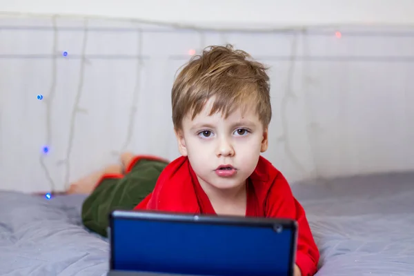 Симпатичный Мальчик Лежит Кровати Смотрит Скрижаль Онлайн Обучение Общение Интернете — стоковое фото