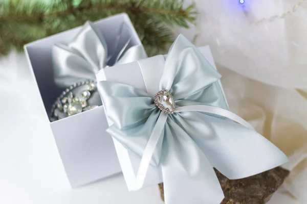 一种圣诞礼物 用漂亮的弓装饰在浅色的背景上 用冷杉枝条装饰 有选择的重点 圣诞节和新年的概念 横幅的背景 — 图库照片