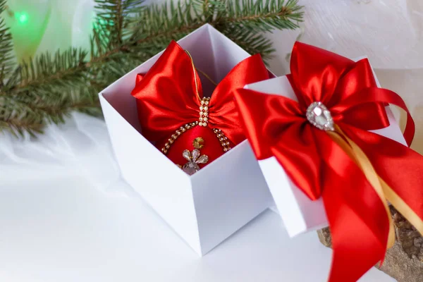 Рождественский Подарок Украшенный Красивым Бантом Светлом Фоне Еловой Веткой Подарки — стоковое фото