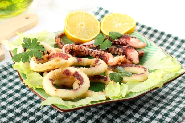 Жареный кальмар с салатом и лимоном — стоковое фото
