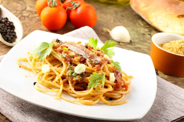 Pasta con anchoas, tomates, ajo y pan rallado Imagen De Stock