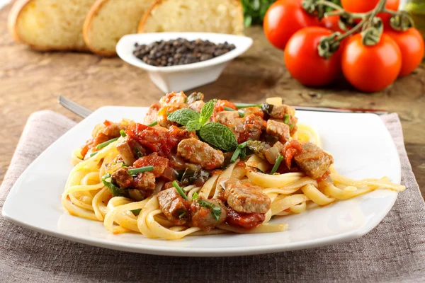 Pasta con trozos de atún fresco, tomate y menta Imagen de stock