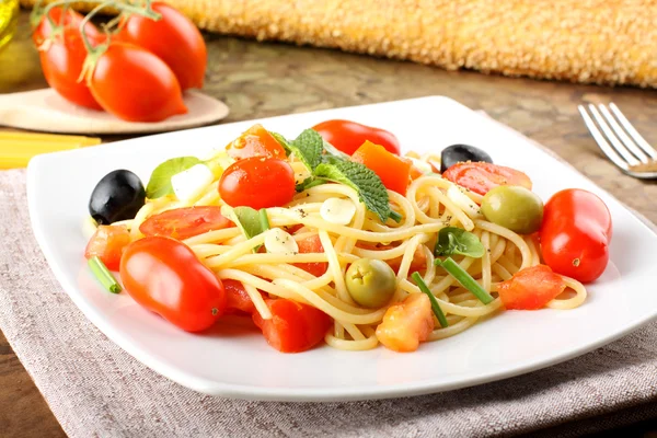 Espaguete com tomates frescos, azeitonas e hortelã — Fotografia de Stock