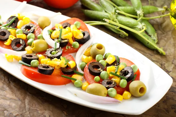 Ensalada de tomate, aceitunas, maíz y guisantes —  Fotos de Stock