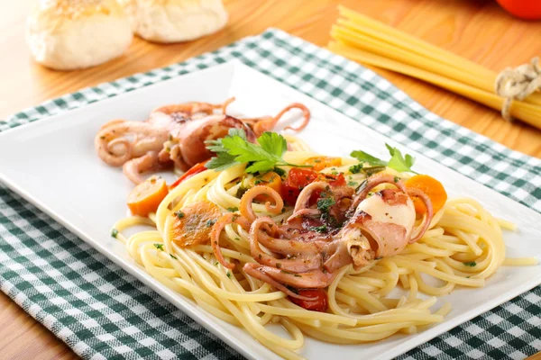 Pasta with octopus, tomatoes and carrots — Stock Photo, Image