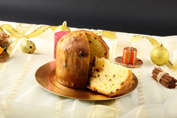 Mesa con panettone y decoraciones navideñas sobre fondo complejo — Foto de Stock