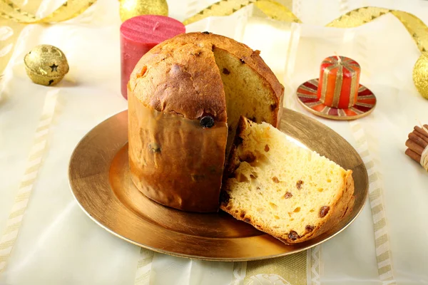 Tavolo con panettone e decorazioni natalizie su sfondo complesso — Foto Stock