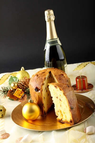 Tisch mit Panettone und Weihnachtsdekoration auf komplexem Hintergrund — Stockfoto