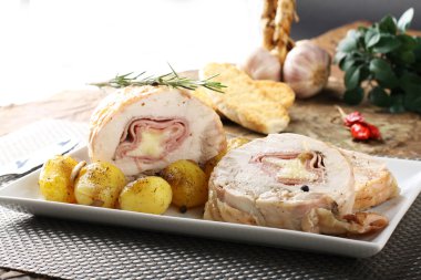 Roulade of stuffed chicken with potatoes and rosemary clipart