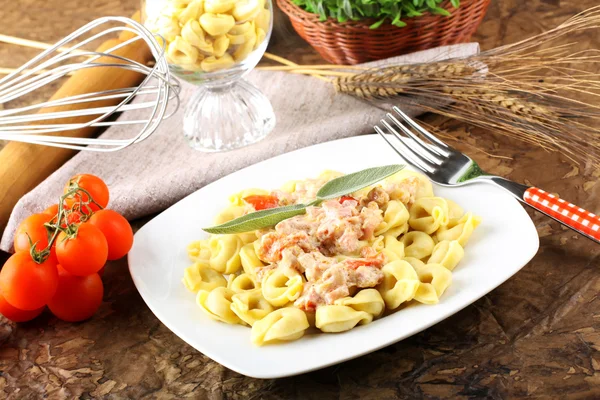 Tortellini com tomate, presunto e creme — Fotografia de Stock