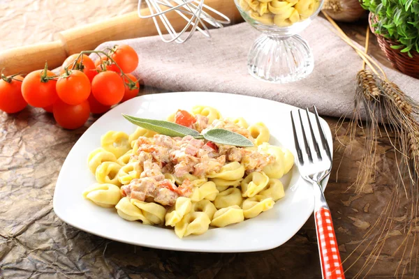 Tortellini com tomate, presunto e creme — Fotografia de Stock